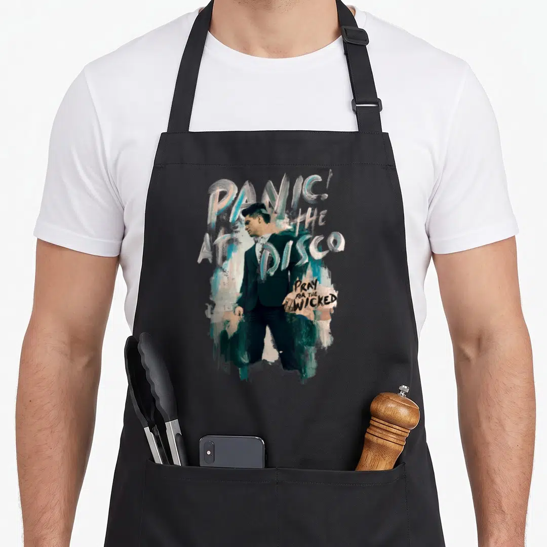 Panic paint apron - Watercolor man in suit over PANIC! AT THE DISCO text with PRAY FOR THE WICKED in blue and pink — shown on a black cotton canvas apron against a white background