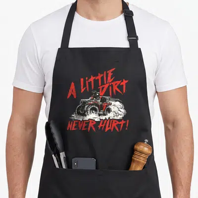 Dirt wheeler guy apron - Red and white distressed ATV rider with text A Little Dirt Never Hurt — shown on a black cotton canvas apron against a white background