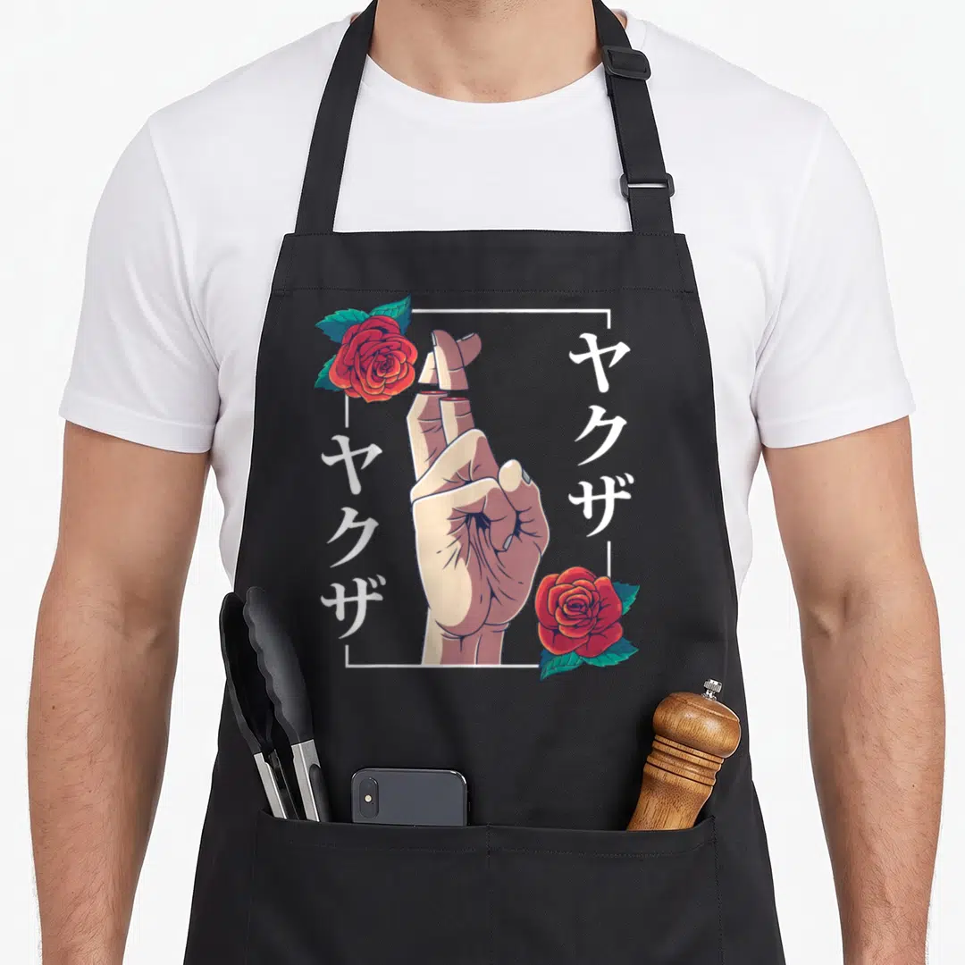 Broken goth apron - Hand with crossed fingers, red roses, and vertical Japanese text in white frame — shown on a black cotton canvas apron against a white background