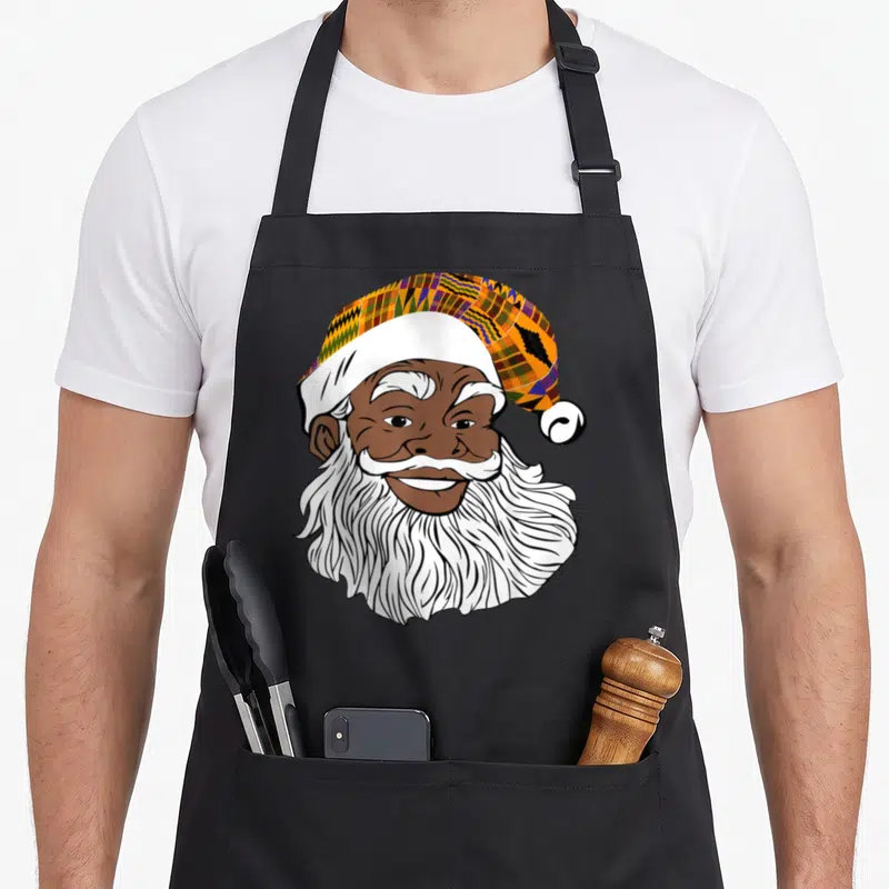 Jolly business apron - Cartoon Black Santa head with Kente pattern hat in orange purple yellow brown white — shown on a black cotton canvas apron against a white background