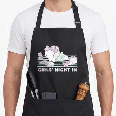 Night reading apron - Hello Kitty lying on blue stripes with open book, mouse, cake, and Girls Night In text — shown on a black cotton canvas apron against a white background