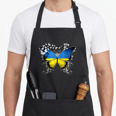 Vintage ukraine ukrainian aprons - Realistic blue and yellow butterfly with white swirls and small flowers — shown on a black cotton canvas apron against a white background