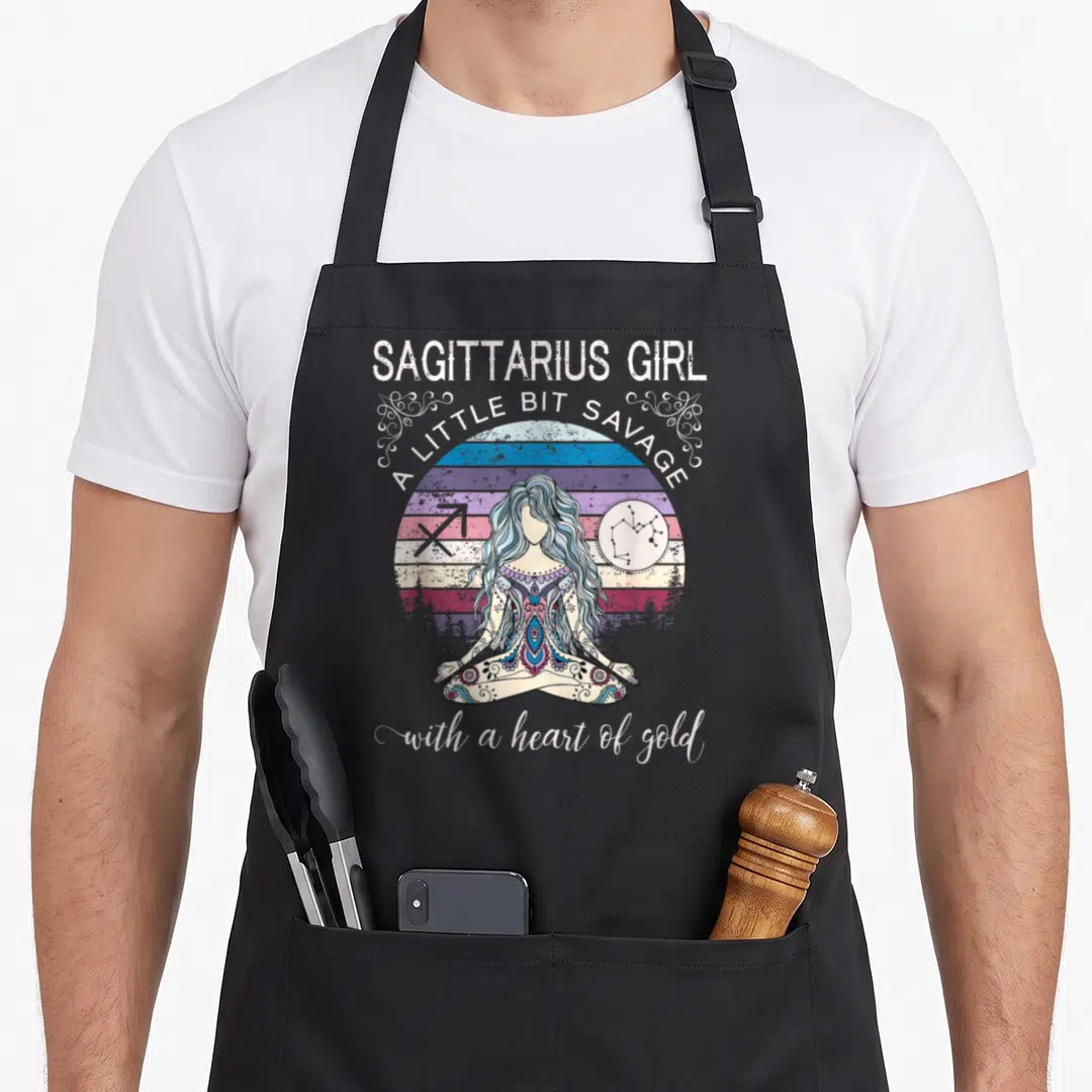 Sagittarius december birthday apron - Cartoon woman in lotus pose with striped sun, Sagittarius symbol — shown on a black cotton canvas apron against a white background