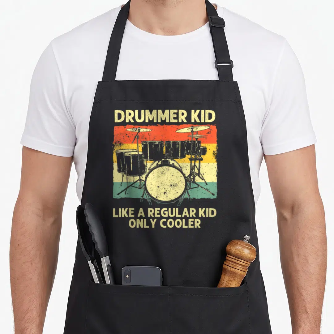 Drumline drum apron - Retro drum kit on red yellow green stripes with text DRUMMER KID LIKE A REGULAR KID ONLY COOLER — shown on a black cotton canvas apron against a white background