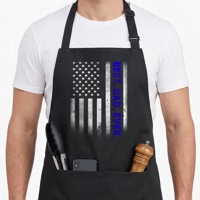 Cute father american flag apron - Vertical BEST. DAD. EVER. text beside distressed white and blue USA flag graphic — shown on a black cotton canvas apron against a white background
