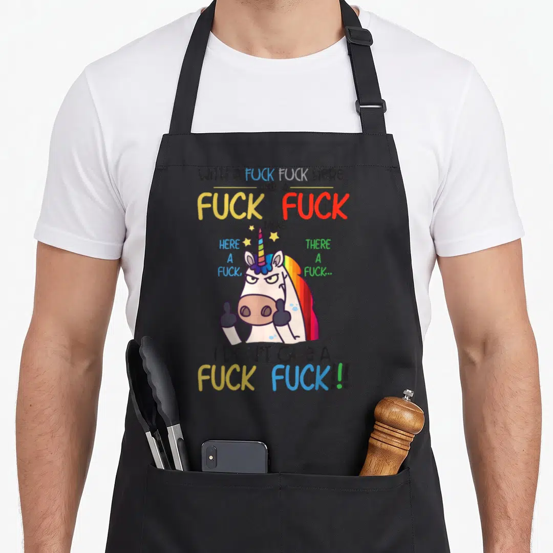Sarcasm lace apron - Cartoon unicorn with rainbow mane giving thumbs up surrounded by colorful vulgar text — shown on a black cotton canvas apron against a white background