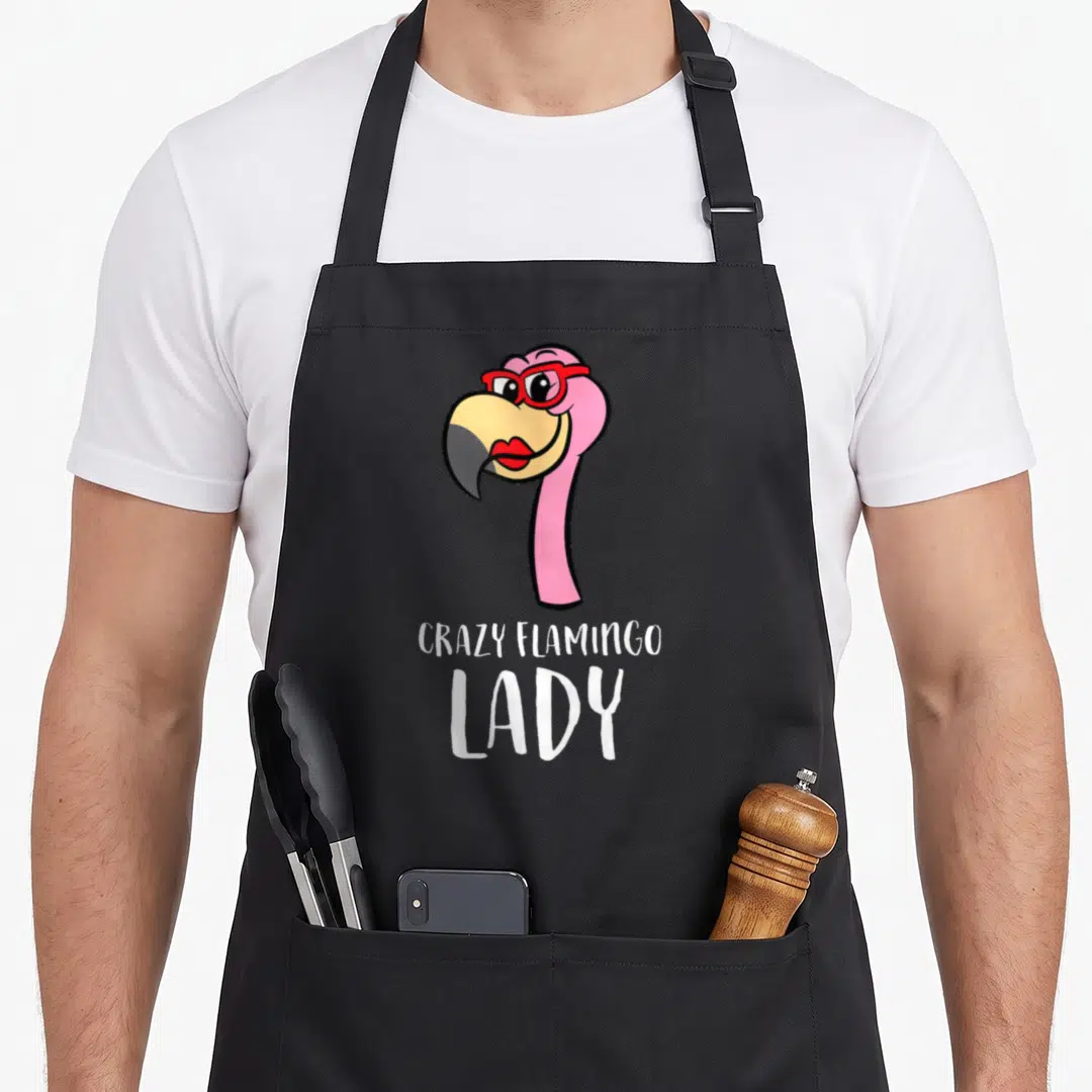 Vintage animal flamingo apron - Cartoon pink flamingo head with red glasses above white text reading Crazy Flamingo Lady — shown on a black cotton canvas apron against a white background