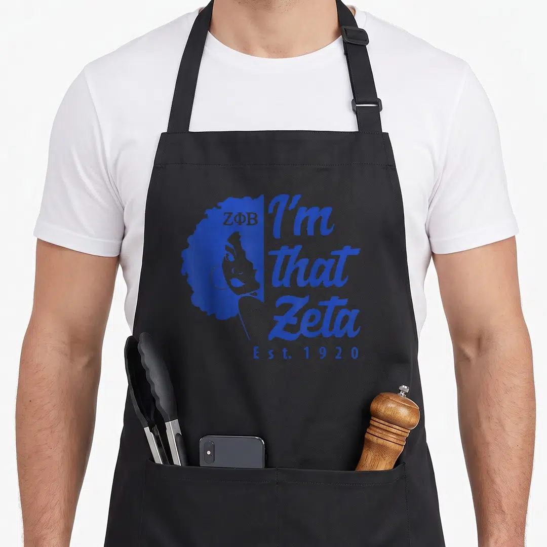 Phi 1920s apron - Blue profile silhouette of woman with curly hair next to I'm that Zeta text and Est 1920 — shown on a black cotton canvas apron against a white background