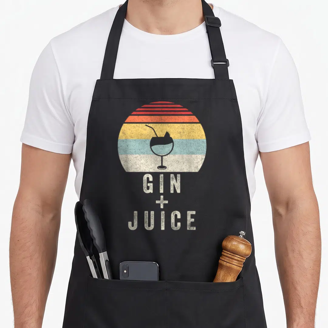 Juice gin apron - Retro striped sunset with cocktail glass and GIN + JUICE text in distressed font — shown on a black cotton canvas apron against a white background