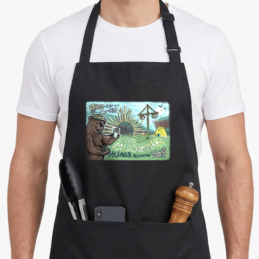 Midsommar bear apron - Brown bear with flower crown holding drink near maypole and GLAD MIDSOMMAR text — shown on a black cotton canvas apron against a white background