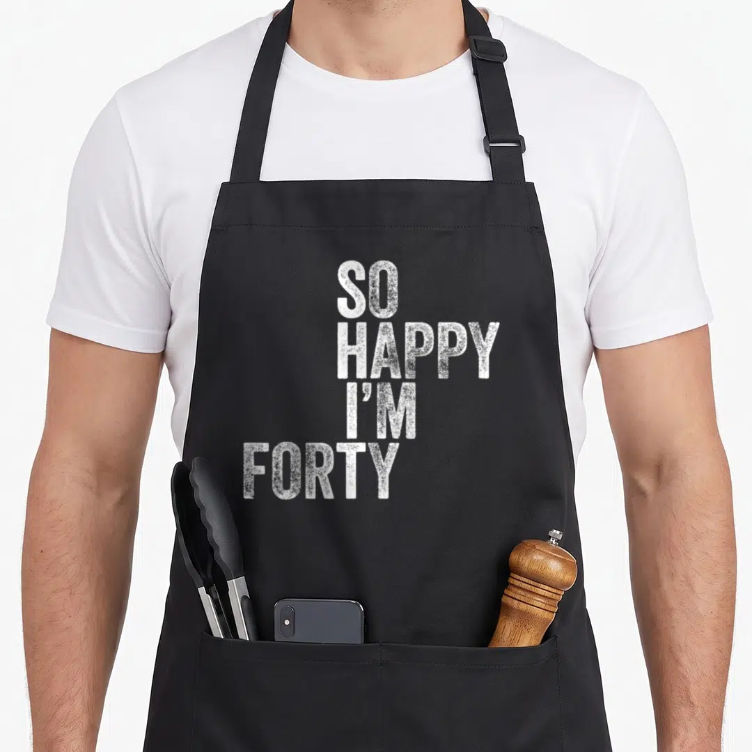 Cute forty 40th birthday apron - White stacked text reading SO HAPPY I'M FORTY in distressed typography — shown on a black cotton canvas apron against a white background