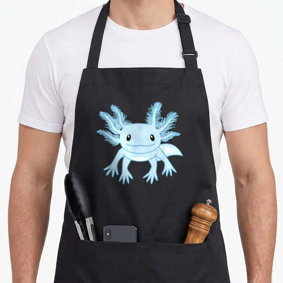 Blue axolotl funny apron - Light blue cartoon axolotl salamander with feathery gills and four arms — shown on a black cotton canvas apron against a white background