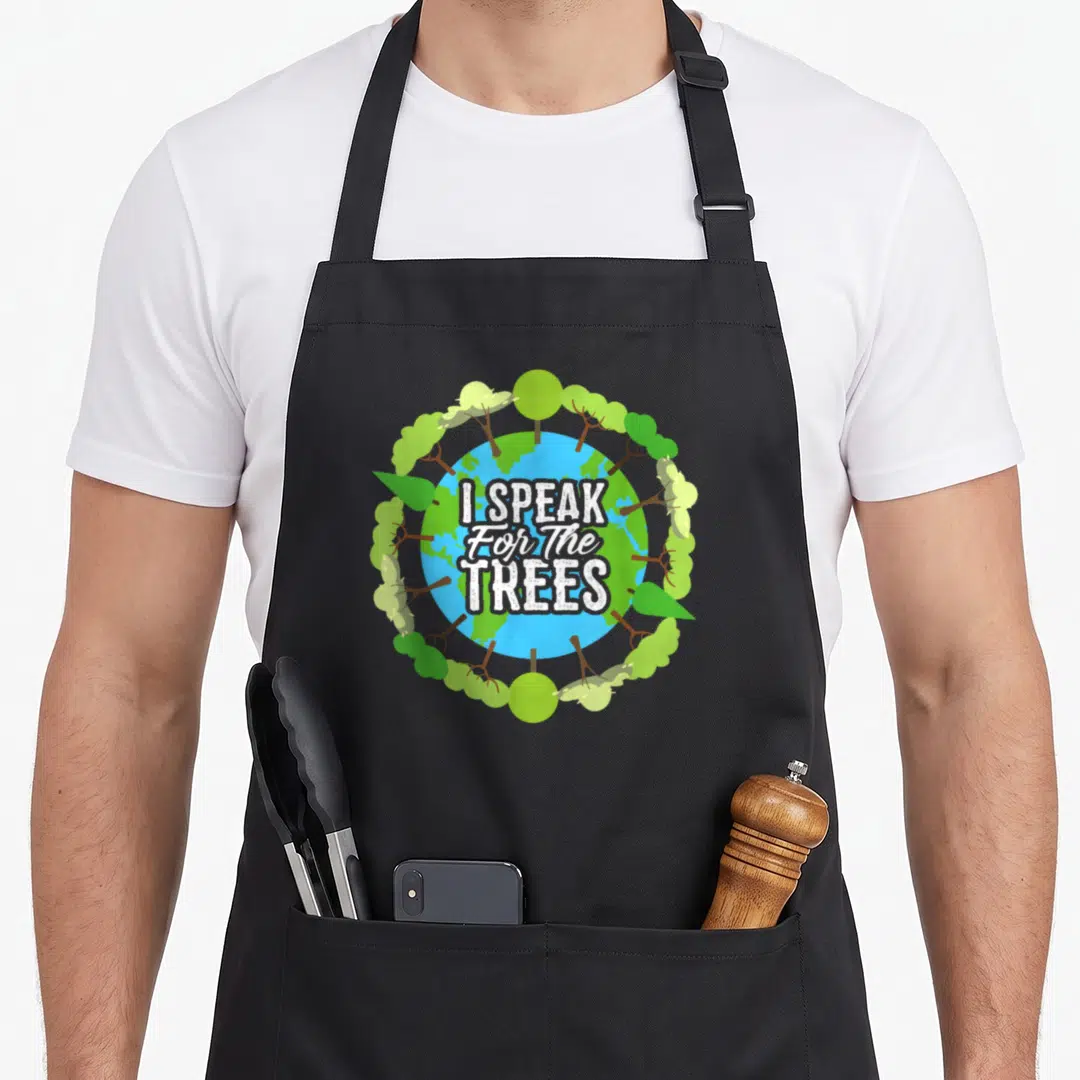 Speak tree apron - I SPEAK For The TREES text over blue green Earth surrounded by trees — shown on a black cotton canvas apron against a white background