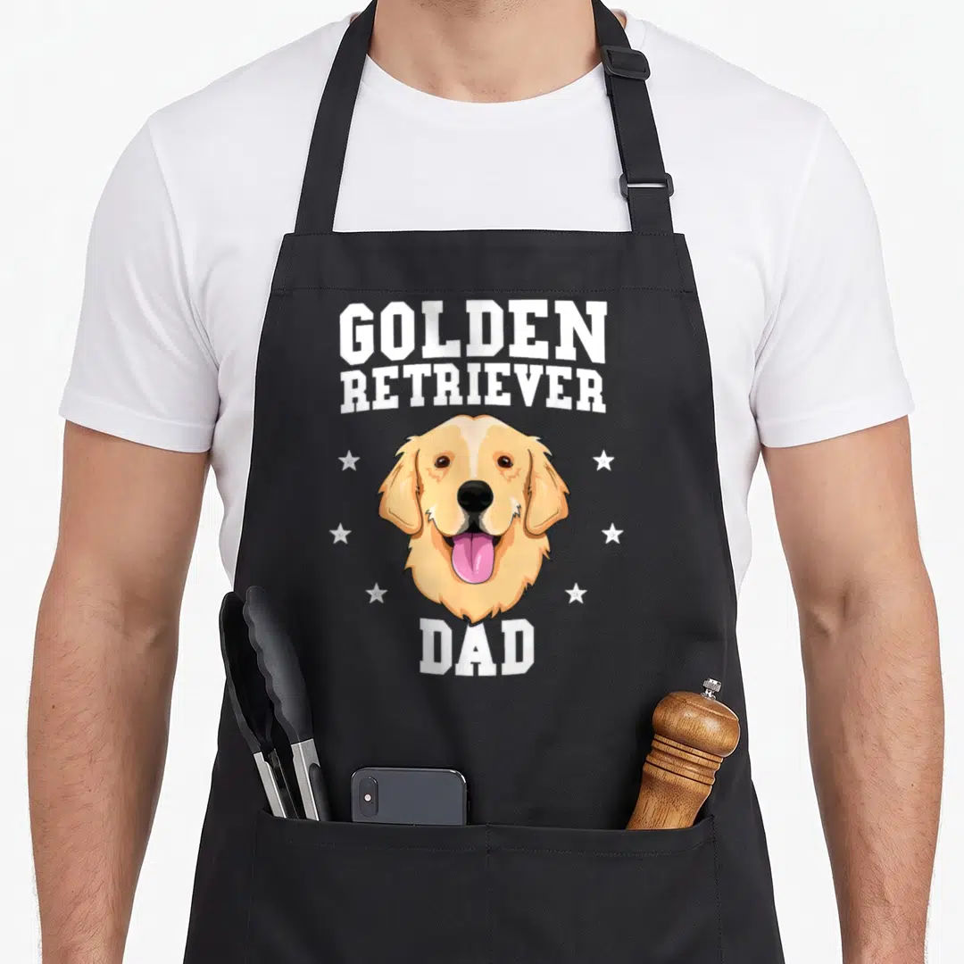 Father dog golden retriever apron - Cartoon golden retriever head with white stars and text GOLDEN RETRIEVER DAD — shown on a black cotton canvas apron against a white background