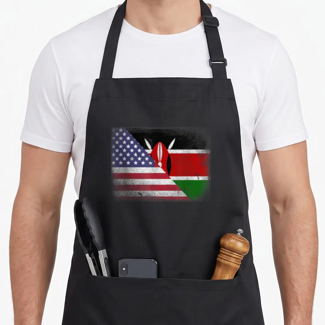 Kenyan kenya american flag apron - Distressed diagonal merge of USA and Kenya flags showing red white blue black green — shown on a black cotton canvas apron against a white background