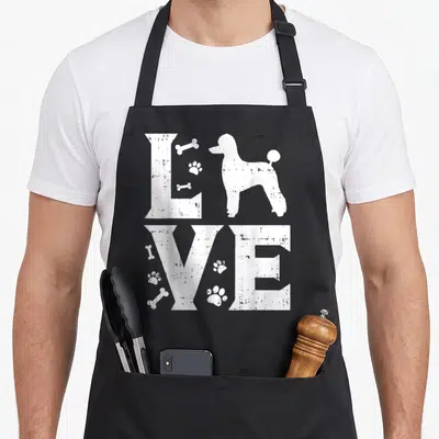 Miniature toy standard size of apron - White distressed LOVE text with poodle silhouette, bones, and paw prints — shown on a black cotton canvas apron against a white background