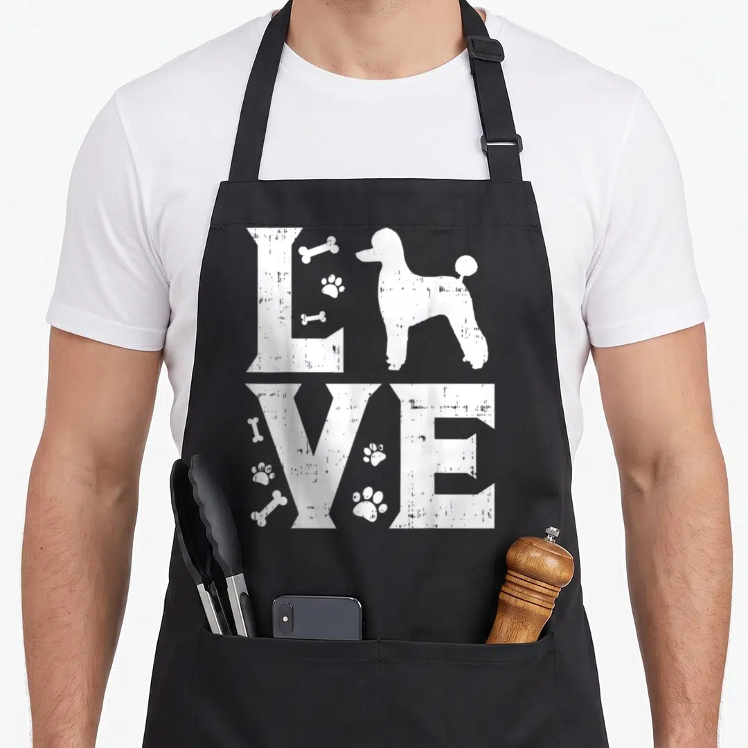 Miniature toy standard size of apron - White distressed LOVE text with poodle silhouette, bones, and paw prints — shown on a black cotton canvas apron against a white background