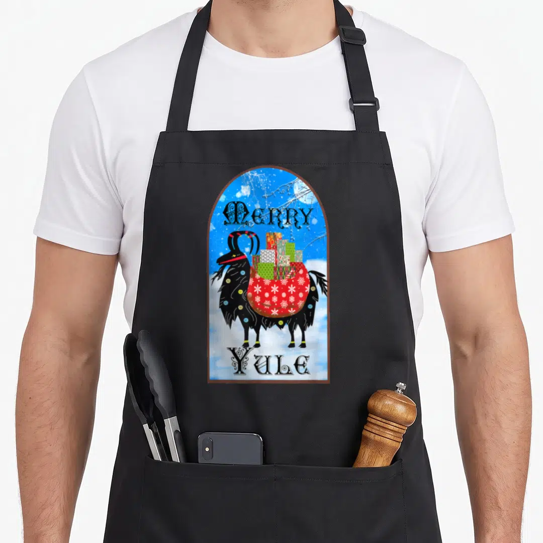 Winter retro christmas aprons - Black goat carrying red snowflake sack between Merry and Yule text in brown arch — shown on a black cotton canvas apron against a white background