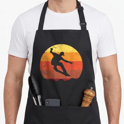 Funny skateboard best skater skateboarder accessories stuff apron - Grey surfer silhouette on striped yellow orange red — shown on a black cotton canvas apron against a white background