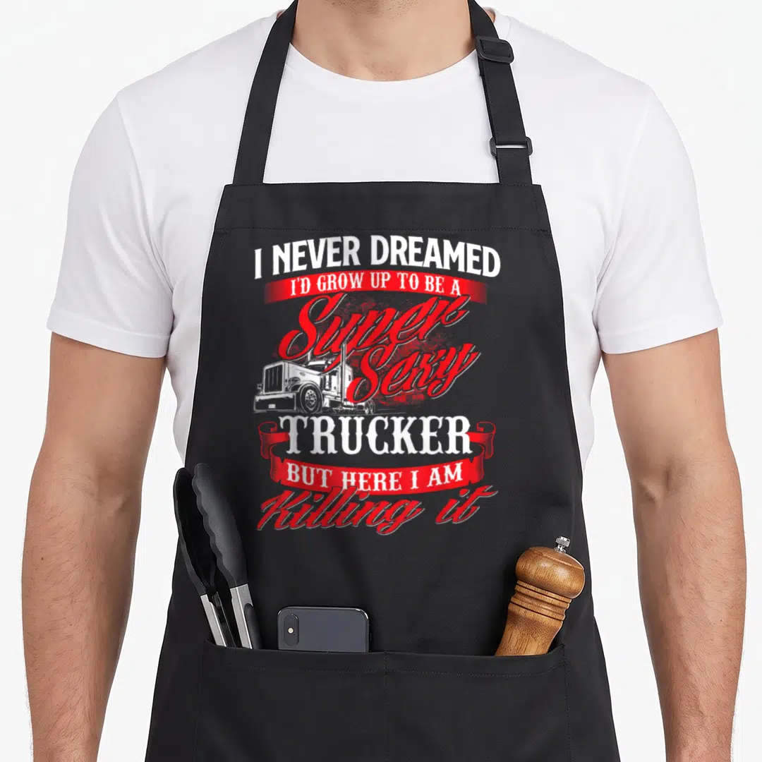 Trucker driver rig semi truck apron - Stacked red and white text with a white truck graphic and ribbon banners — shown on a black cotton canvas apron against a white background