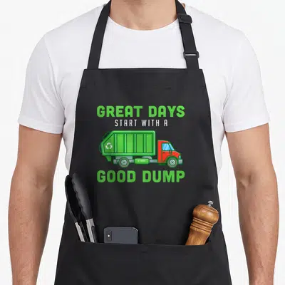 Garbageman truck apron - Cartoon lime green garbage truck with red cab and text Great Days Start With A Good Dump — shown on a black cotton canvas apron against a white background