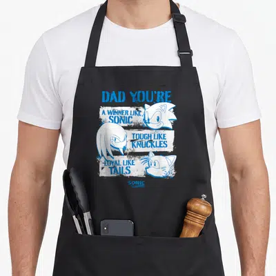 Funny distressed father day apron - Blue distressed text listing Sonic, Knuckles, and Tails qualities next to character — shown on a black cotton canvas apron against a white background