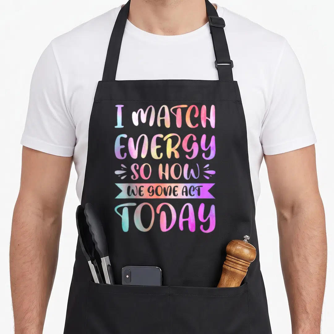 Gone act apron - Stacked I Match Energy So How We Gone Act Today text in pink blue yellow purple watercolor gradients — shown on a black cotton canvas apron against a white background