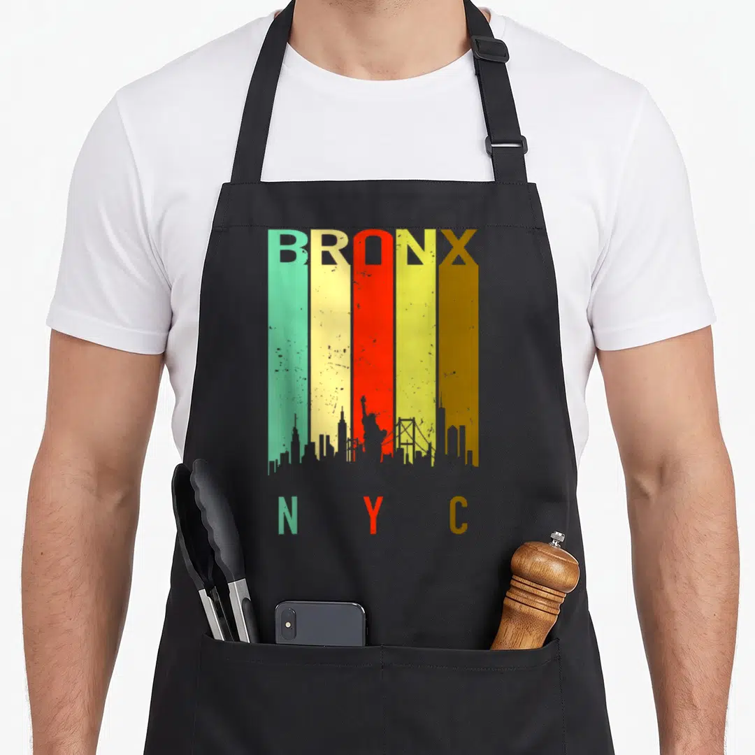 Bronx nyc new york apron - Retro five stripe skyline with BRONX and N Y C text in teal yellow red olive brown — shown on a black cotton canvas apron against a white background