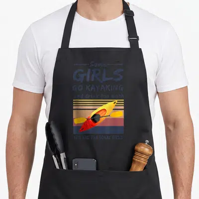 Kayaking kayak lover apron - Retro yellow and red kayak over striped sunset with humorous paddling text — shown on a black cotton canvas apron against a white background