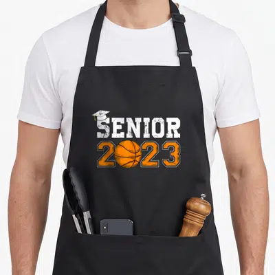 Graduate senior graduation class player apron - Distressed SENIOR text with cap and orange 2023 with basketball — shown on a black cotton canvas apron against a white background