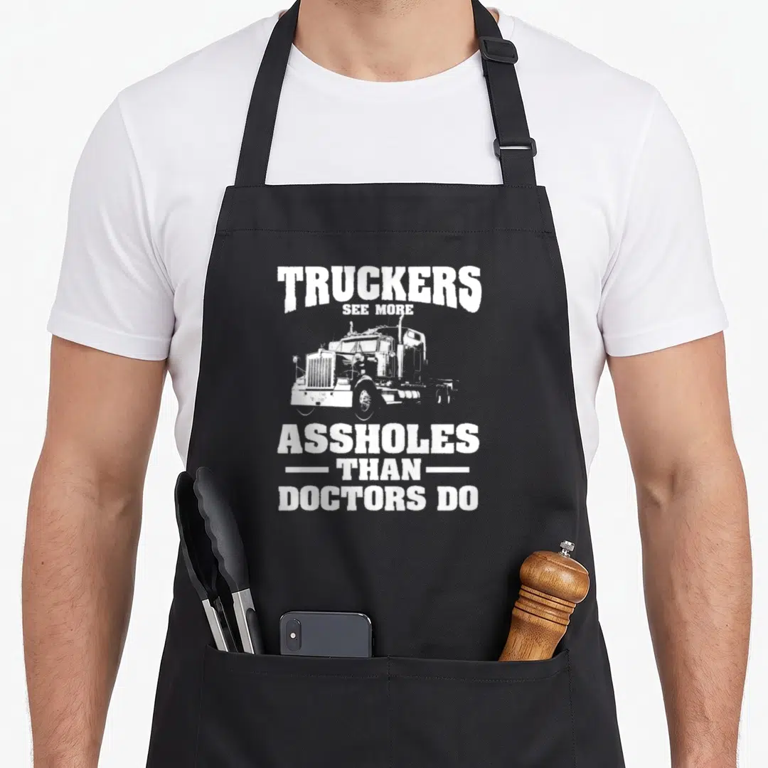 Doctor semi truck apron - White distressed semi-truck between text reading TRUCKERS SEE MORE ASSHOLES THAN DOCTORS DO — shown on a black cotton canvas apron against a white background