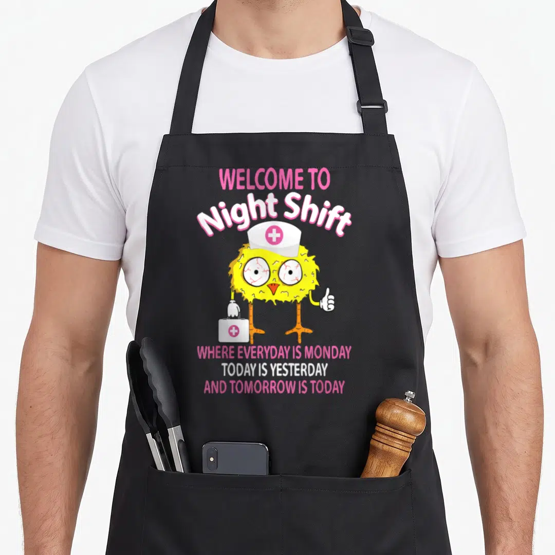 Bsn nursing aprons - Yellow cartoon chick with red eyes holding a white medical bag under pink and white text — shown on a black cotton canvas apron against a white background
