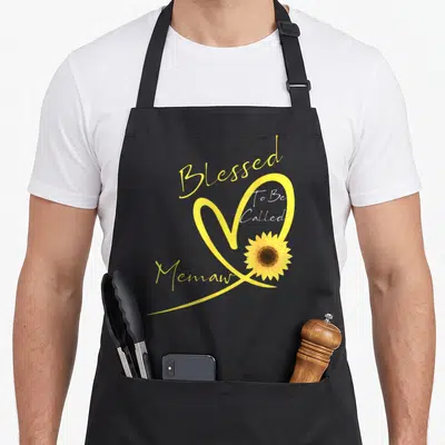 Memaw sunflower apron - Blessed To Be Called Memaw text around yellow heart outline with sunflower — shown on a black cotton canvas apron against a white background