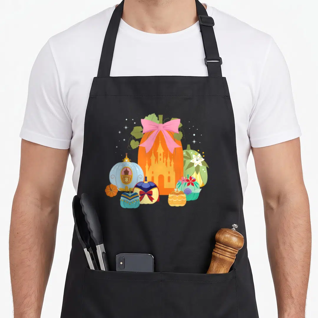 Princess pumpkin apron - Orange pumpkin with castle silhouette and pink bow surrounded by smaller themed pumpkins — shown on a black cotton canvas apron against a white background