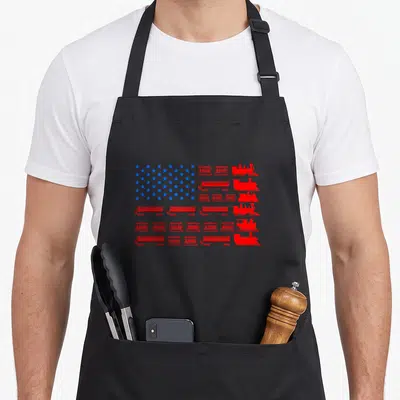 Model train apron - Red trains and blue stars arranged in a USA flag pattern on a black apron — shown on a black cotton canvas apron against a white background