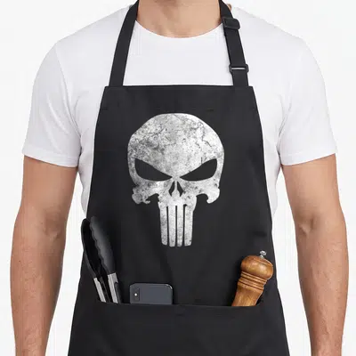 Comic skull apron - Large white distressed skull graphic centered on grey background — shown on a black cotton canvas apron against a white background