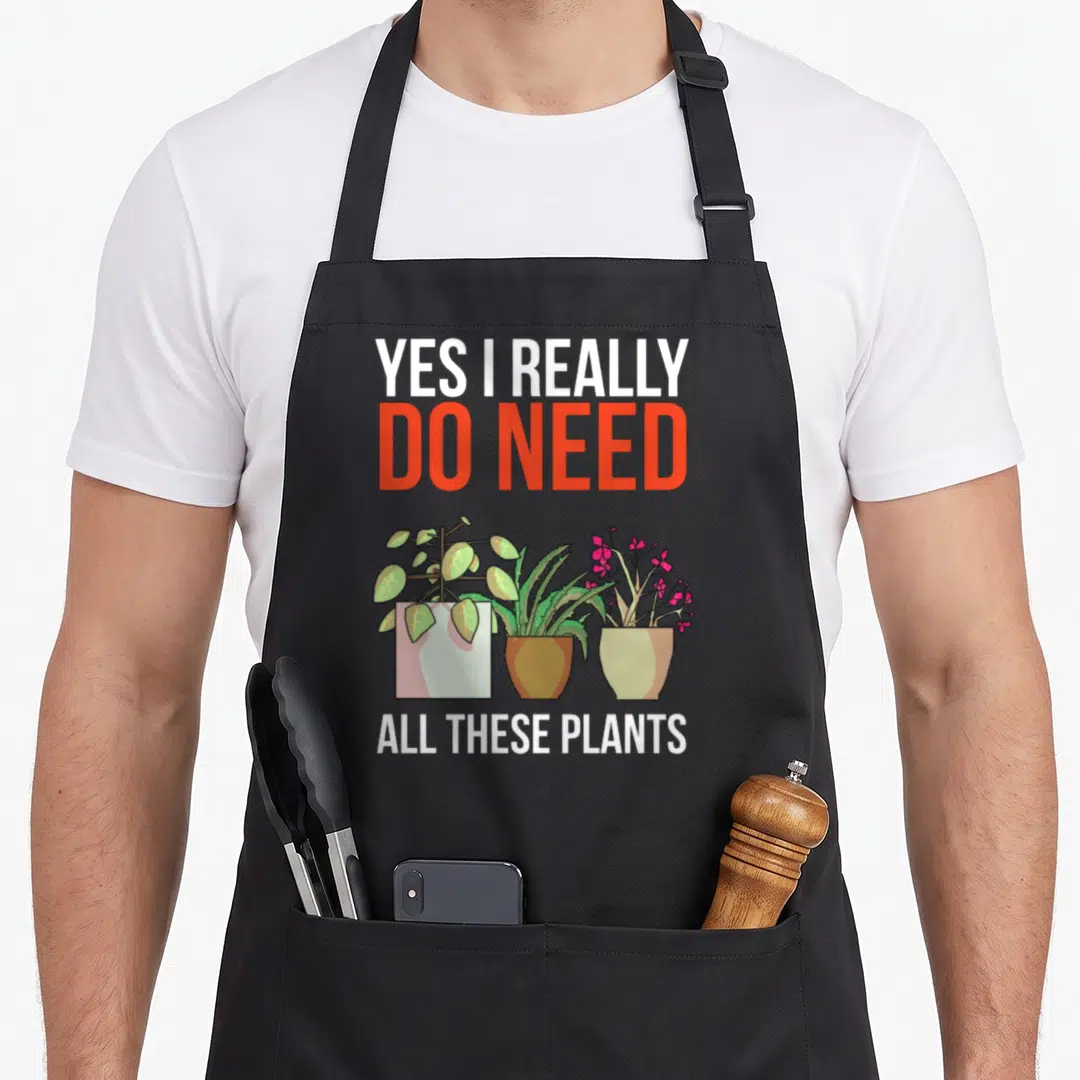 Plant gardening do i need an apron - Three cartoon potted plants with text Yes I Really Do Need All These Plants — shown on a black cotton canvas apron against a white background