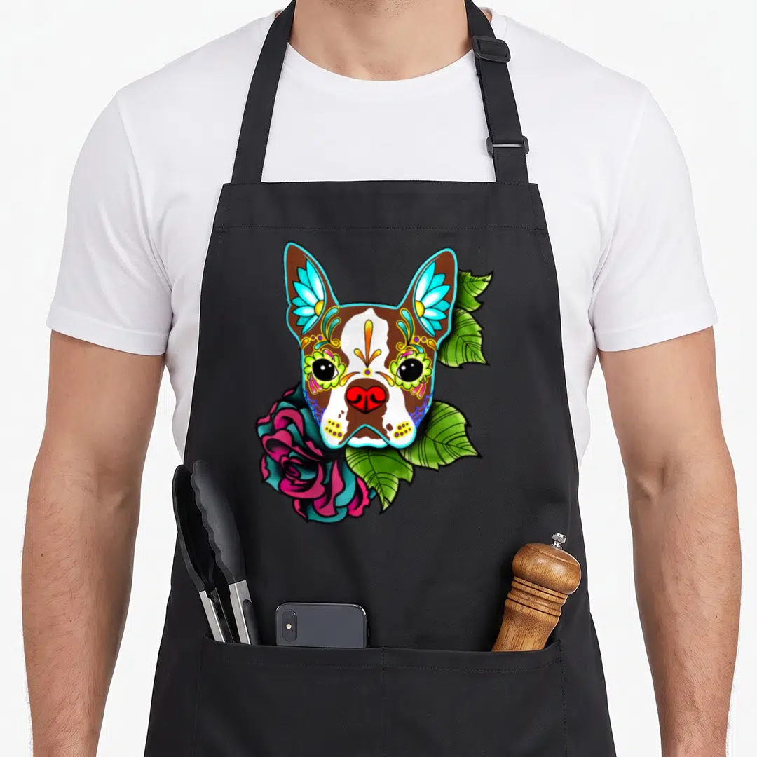 Boston day of the dead apron - Cartoon Boston Terrier face with sugar skull makeup, pink rose, and green leaves — shown on a black cotton canvas apron against a white background