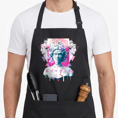Statue vaporwave apron - Medusa bust with Ancient Beauty Kanji, pink temple, and geometric triangles — shown on a black cotton canvas apron against a white background