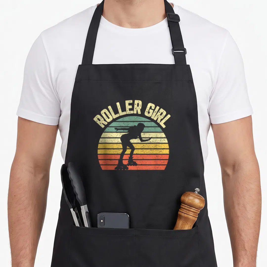 Derby 70s apron - Roller Girl text over striped retro sunset with skater silhouette — shown on a black cotton canvas apron against a white background