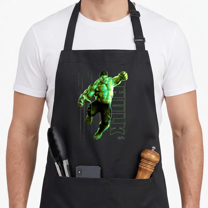 Jump infinity apron - Realistic green Hulk figure jumping over vertical HULK text with Avengers logo in corner — shown on a black cotton canvas apron against a white background