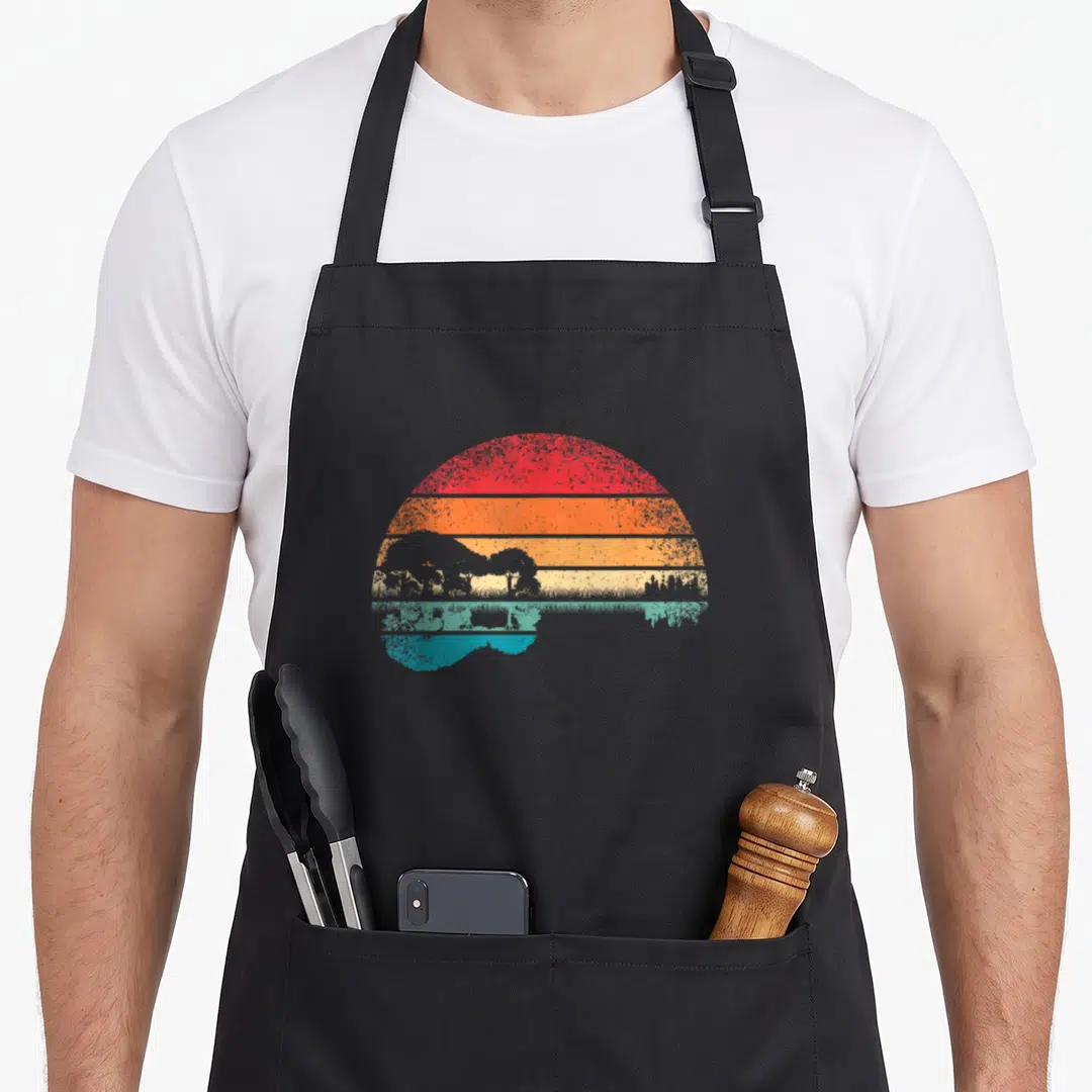 Acoustic guitar retro lovers apron - Retro sunset with red orange yellow stripes and teal landscape silhouette — shown on a black cotton canvas apron against a white background