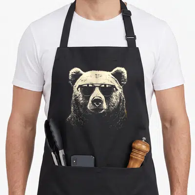 Grizzly punk rock apron - Realistic gold bear head wearing dark sunglasses facing forward — shown on a black cotton canvas apron against a white background