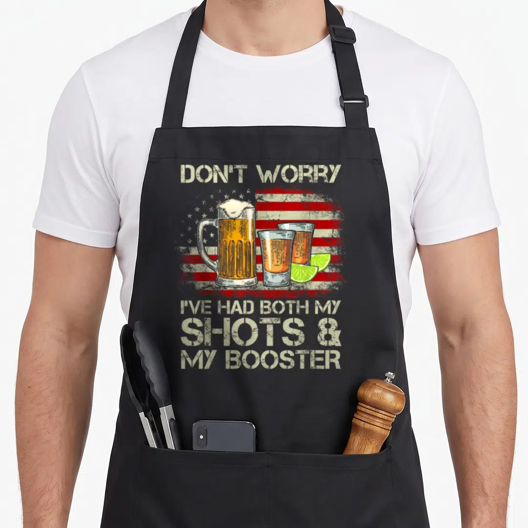 Worry american flag apron - Beer mug, two shot glasses with lime slices in front of a distressed American flag — shown on a black cotton canvas apron against a white background