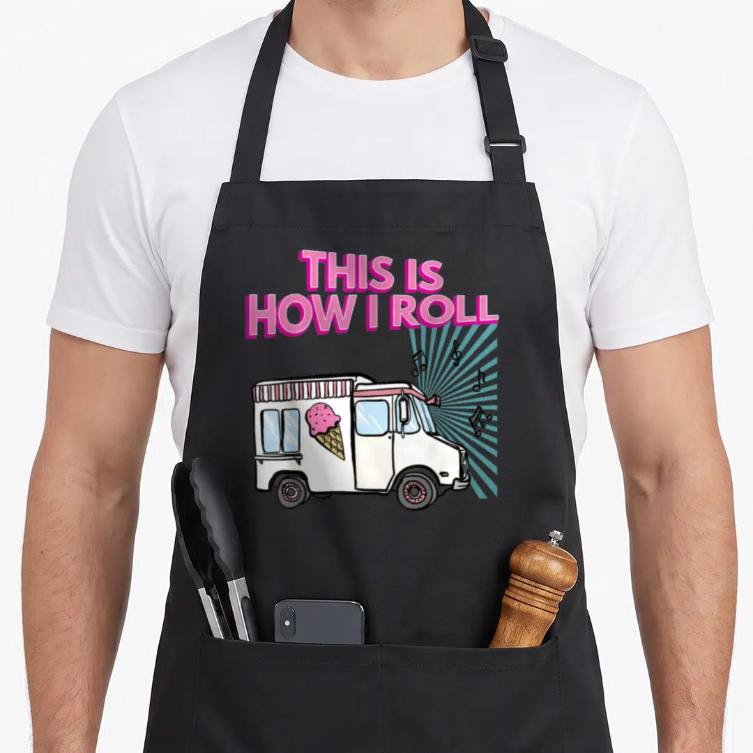 Roll ice cream apron - Stacked pink text above white ice cream truck with blue sunburst and music notes — shown on a black cotton canvas apron against a white background