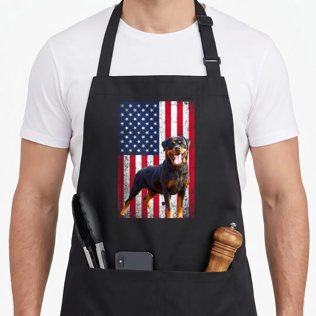 Dog 4th of july apron - Rottweiler photo standing in front of a distressed red white and blue American flag background — shown on a black cotton canvas apron against a white background