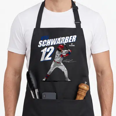 Kyle baseball apron - Baseball player in batting stance with KYLE SCHWARBER 12 text in red white blue — shown on a black cotton canvas apron against a white background