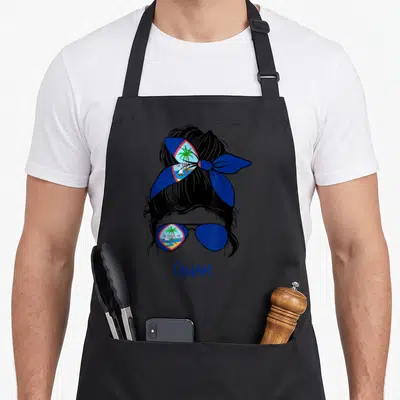 Guamanian guam aprons - Minimalist woman silhouette with Guam flag in headband and sunglasses lens below text — shown on a black cotton canvas apron against a white background