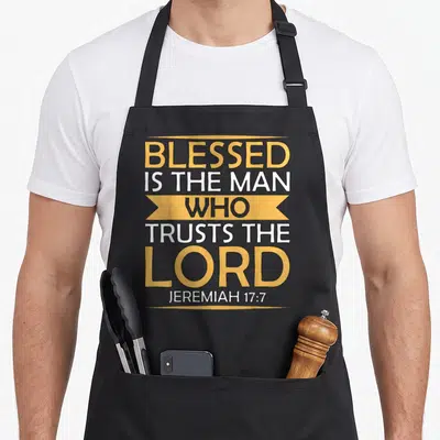 Scripture bible verse apron - Yellow banner containing WHO surrounded by white and gold text reading BLESSED IS THE MAN — shown on a black cotton canvas apron against a white background