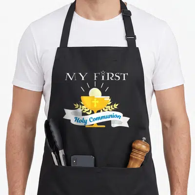 Catholic communion aprons - Yellow chalice with host and wheat ribbon reading MY FIRST Holy Communion — shown on a black cotton canvas apron against a white background